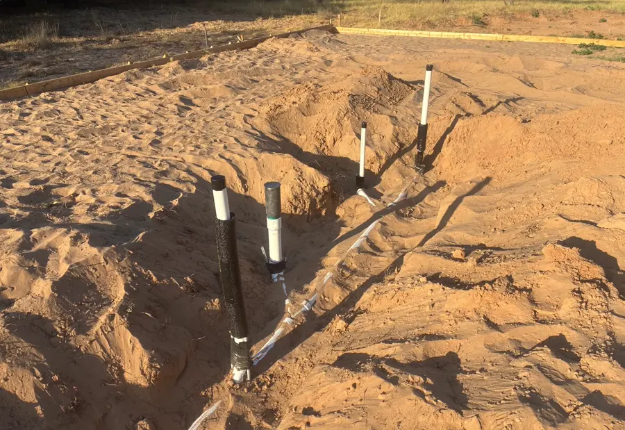 Pipes rising out of a concrete slab, roughed in for a new building